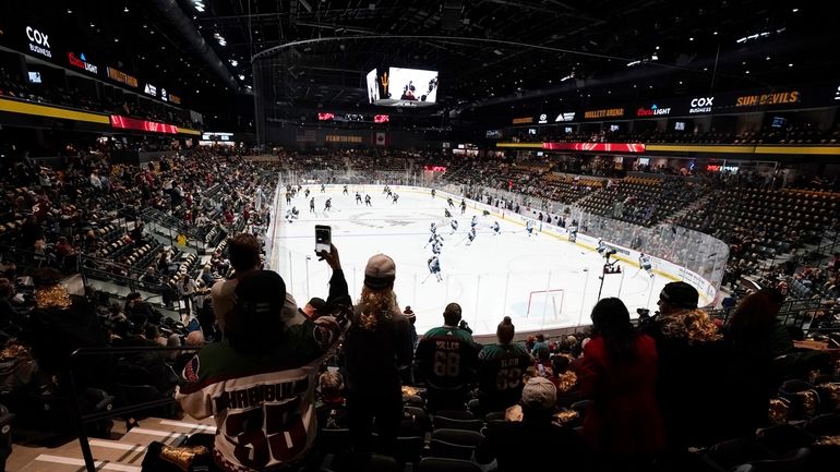 Fans watch players as they warm up prior to the...