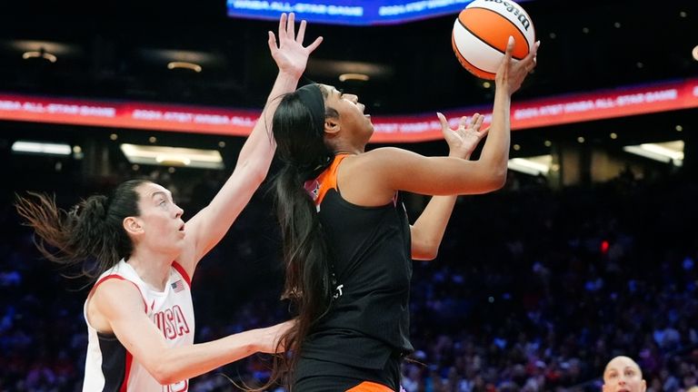 Angel Reece, front right, of Team WNBA, drives past Breanna...