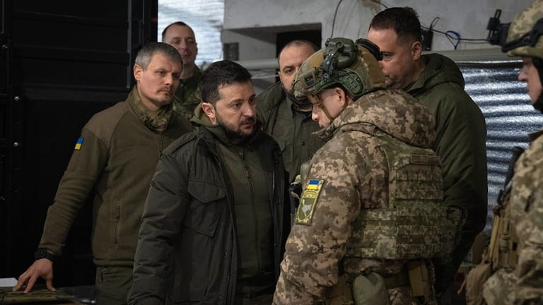 Ukrainian President Volodymyr Zelenskyy talks to the commander of Ukraine's...