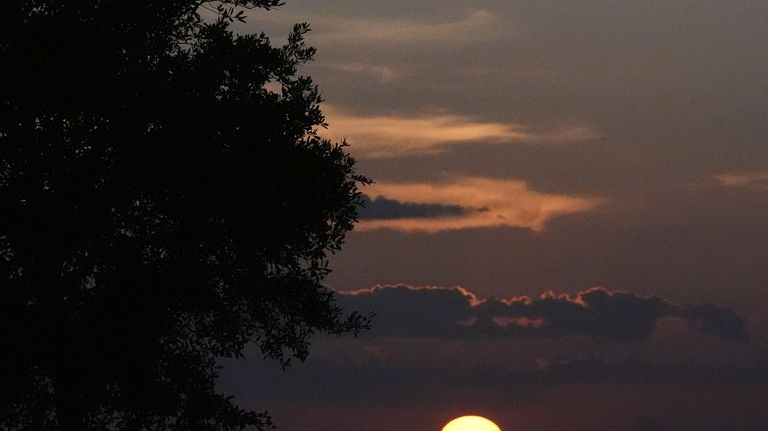 The sun sets in the Florida Everglades as hunters wait...