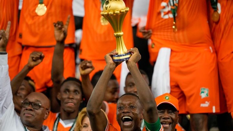 Ivory Coast 's Max-Alain Gradel lifts the trophy after winning...