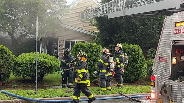 Firefighters at the house on Spindle Road in Hicksville Sunday.