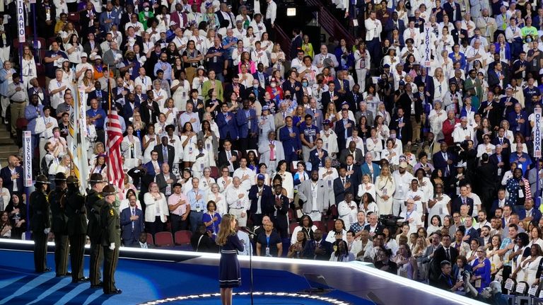 People in the crowd wear white during the Pledge of...