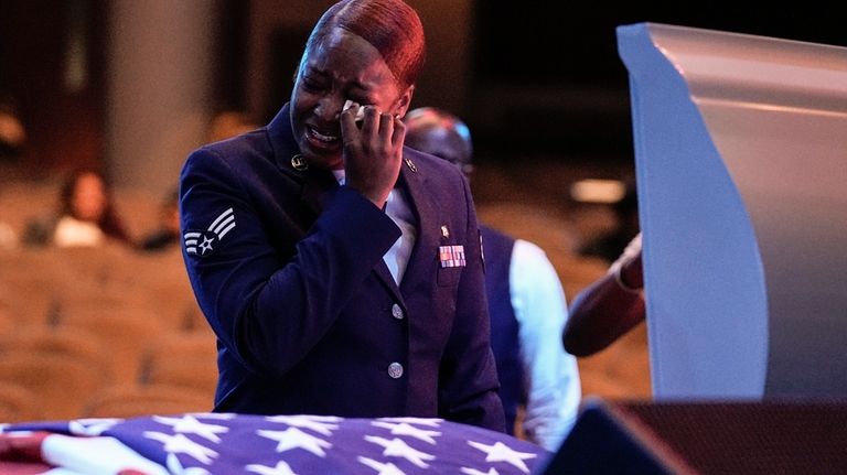 U.S. Air Force personnel stand near the coffin of slain...