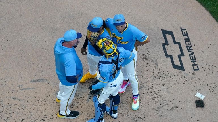 Milwaukee Brewers' Freddy Peralta, top center, meets on the mound...