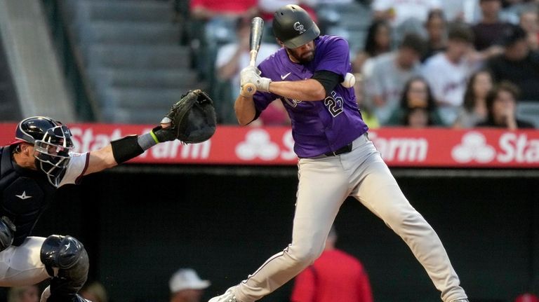 Colorado Rockies' Jacob Stallings, right, is hit by a pitch...