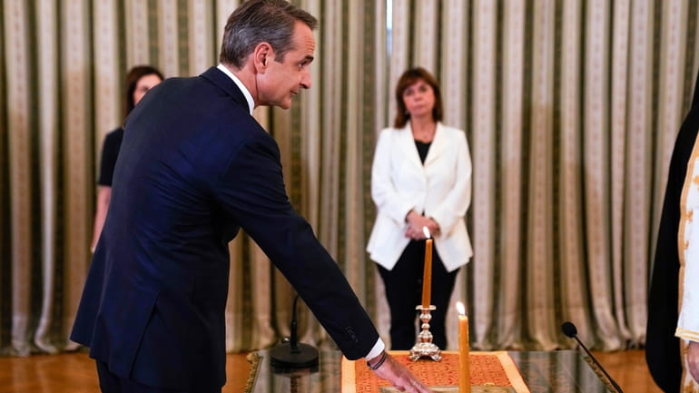 Greece's Prime Minister Kyriakos Mitsotakis takes the oath during a...