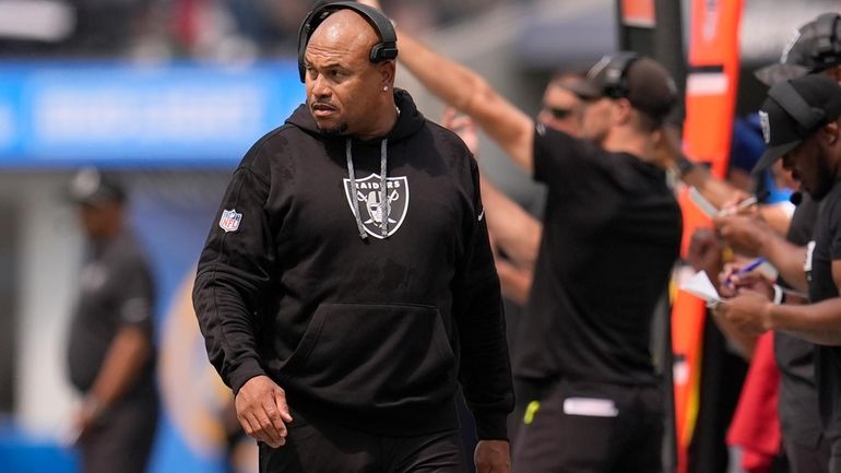 Las Vegas Raiders head coach Antonio Pierce walks on the...