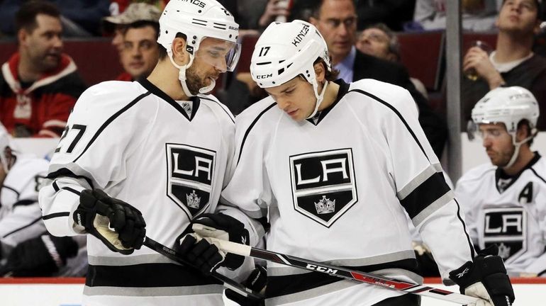 Los Angeles Kings' Alec Martinez, left, talks to Daniel Carcillo...