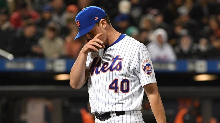 Mets starting pitcher Chris Bassitt walks to the dugout after...