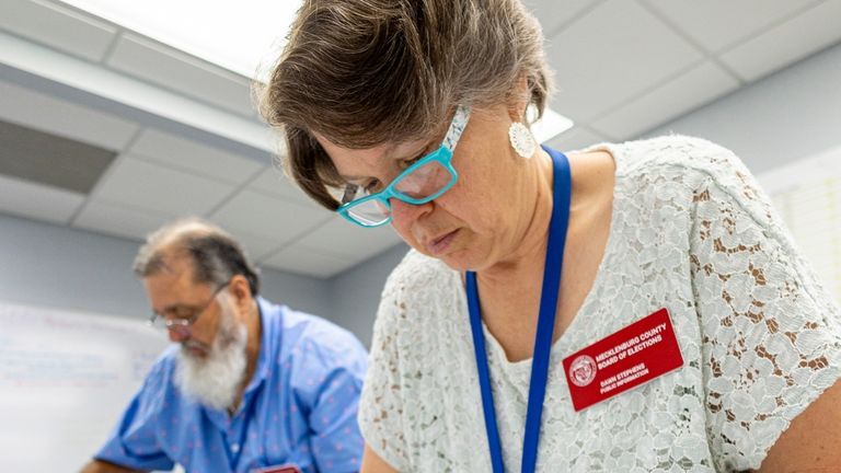 Dawn Stephens, right, and Duane Taylor prepare ballots to be...