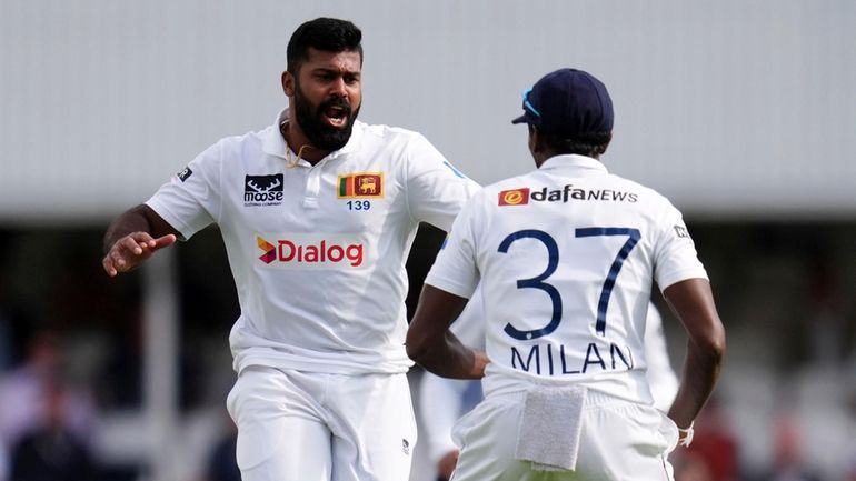 Sri Lanka's Lahiru Kumara, left, celebrates taking the wicket of...