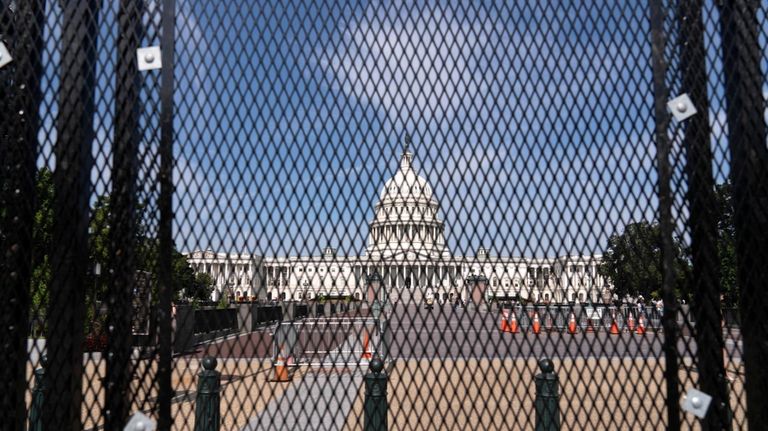 The U.S. Capitol is seen behind a security fence a...