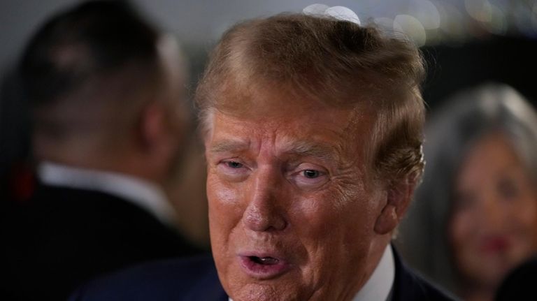 Former President Donald Trump talks to supporters during a stop...