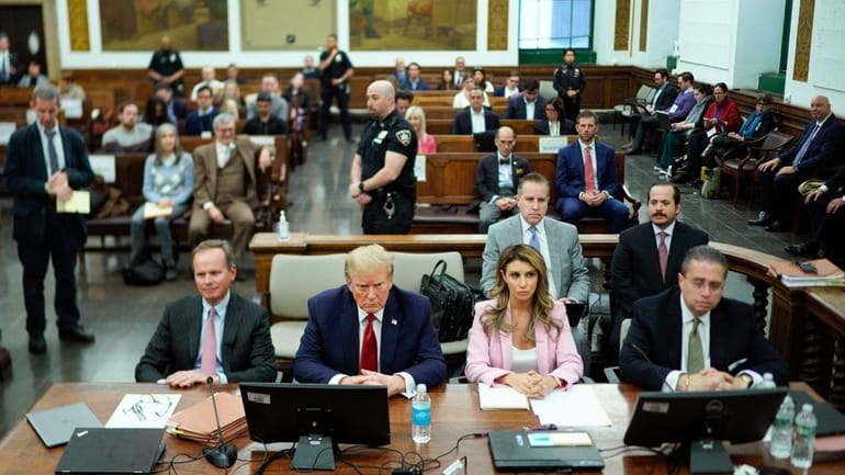 Former President Donald Trump, second from left, sits at the...
