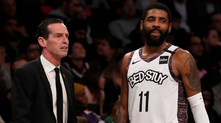Nets head coach Kenny Atkinson and guard Kyrie Irving look on...