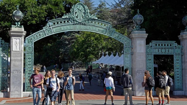 Students walk past Sather Gate on the University of California,...