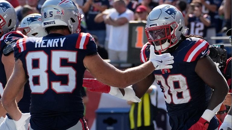 New England Patriots running back Rhamondre Stevenson, right, celebrates after...