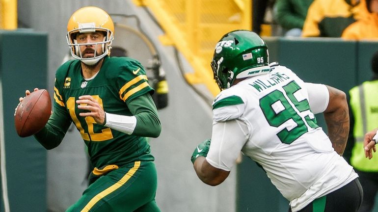 Green Bay Packers quarterback Aaron Rodgers scrambles away from New...