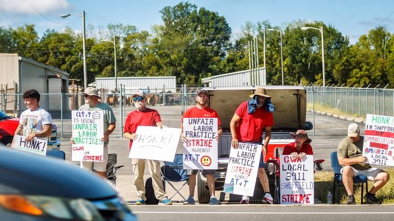 AT&T workers from the CWA Local 3911 picket outside an...