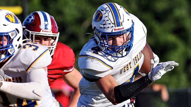 West Islip RB Rocco Carpinello takes the ball around the...