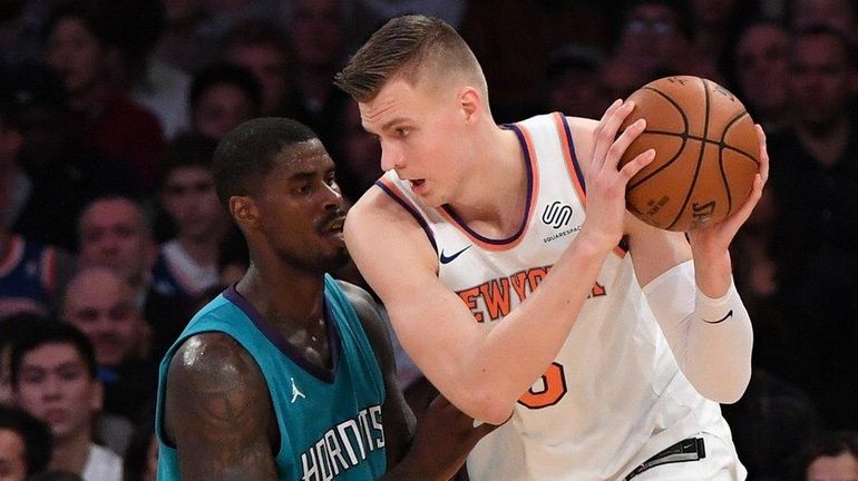 Knicks forward Kristaps Porzingis is defended by Charlotte Hornets forward...