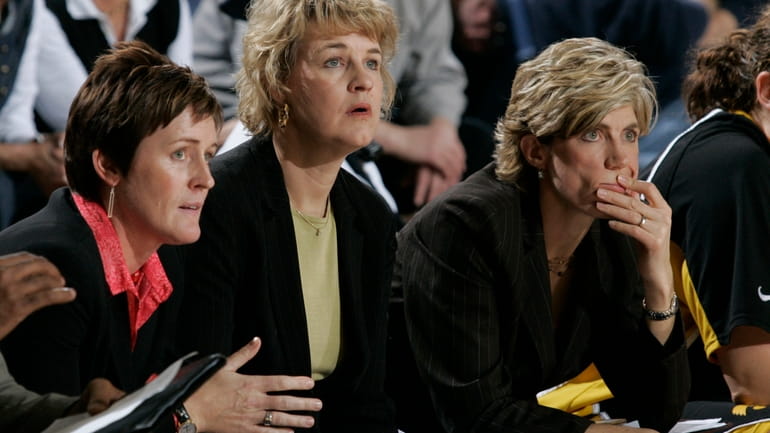 Iowa coach Lisa Bluder is flanked by assistant Jenni Fitzgerald,...