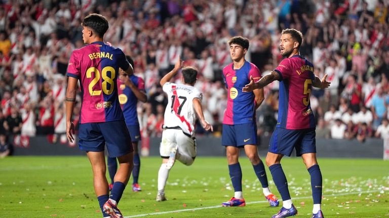 Barcelona players react as Rayo's Unai Lopez celebrates after scoring...