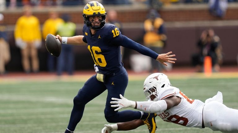 Michigan quarterback Davis Warren (16) throws under pressure from Texas...