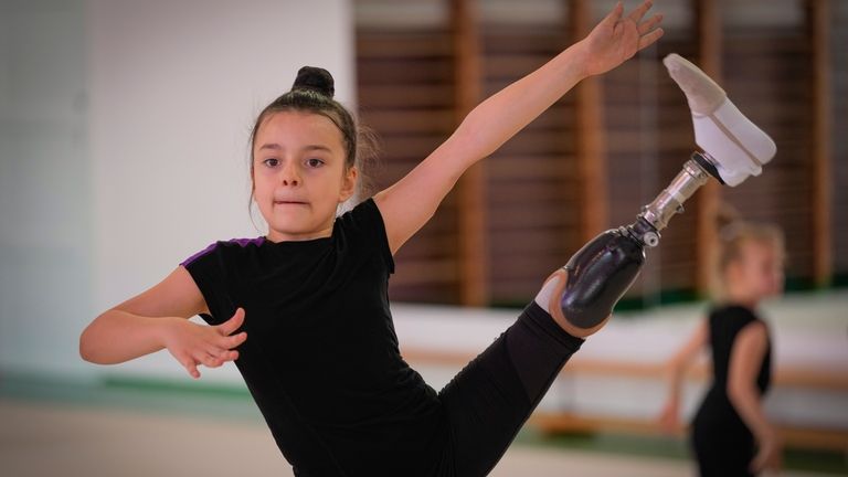 Oleksandra Paskal, an 8-year-old girl with a prosthetic leg, practices...