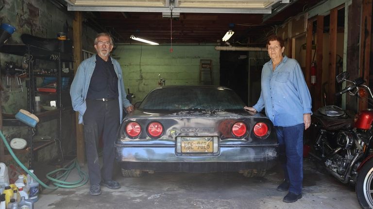 Perry and Kathleen Gallup in their garage with a Corvette...