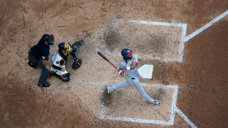 Washington Nationals' CJ Abrams, right, hits a two-run home run...