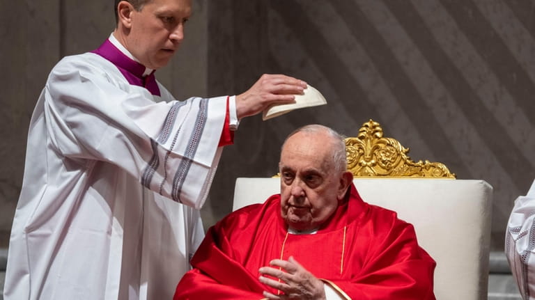 Monsignor Krzysztof Marcjanowicz puts the skull cap on Pope Francis...
