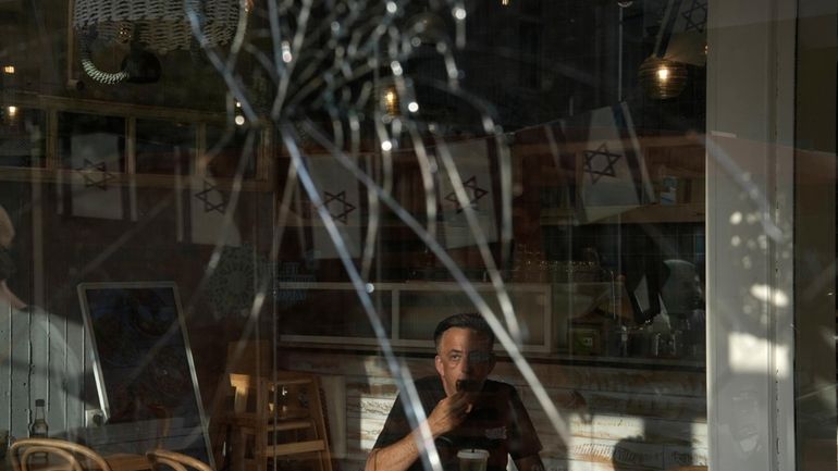 A man eats breakfast in a cafe near the scene...