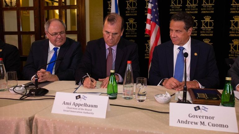 Ami Appelbaum, center, chairman of the Israel Innovation Authority, signs an...