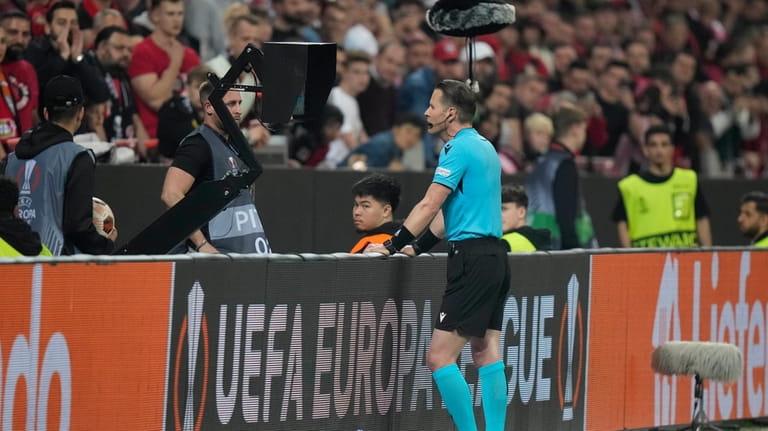 Referee Danny Makkeliececks the VAR during the Europa League second...