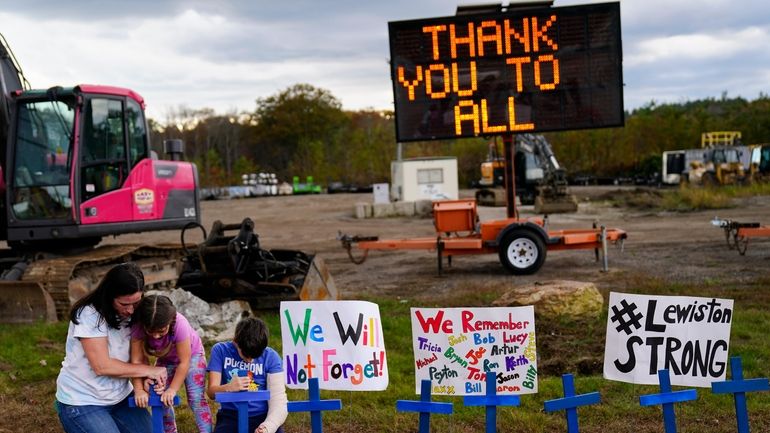 Bre Allard, accompanied by her children Lucy, 5, and Zeke,...