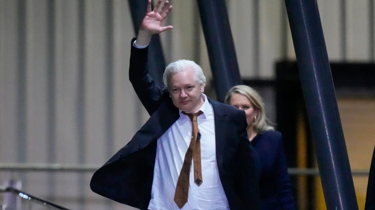 WikiLeaks founder Julian Assange waves after landing at RAAF air...