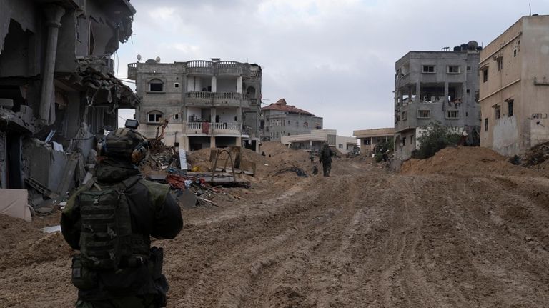 An Israeli soldier walks during the ground offensive on the...