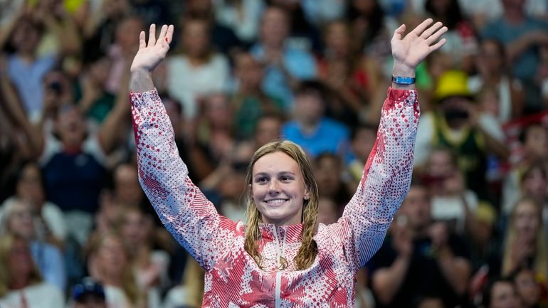 Summer McIntosh, of Canada, waves on the podium after winning...