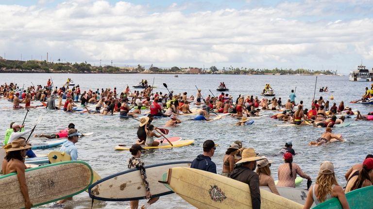 Hundreds of surfers paddle out into the waters of Hanakaoʻo...