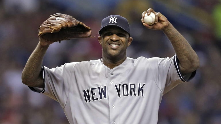 Yankees starting pitcher CC Sabathia reacts after giving up three...