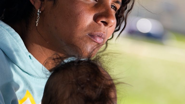 Ivanni Herrera holds her baby Milan Guzman during an interview...