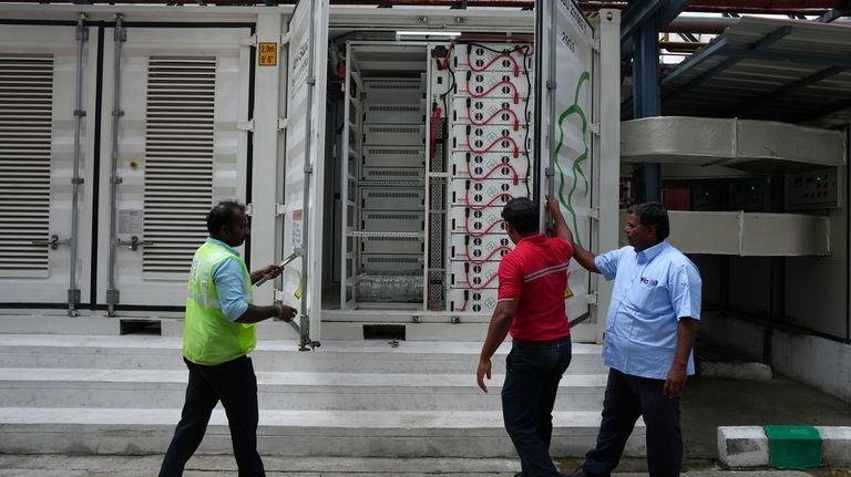 Team leader K. Sridhar, center, closes the doors after a...