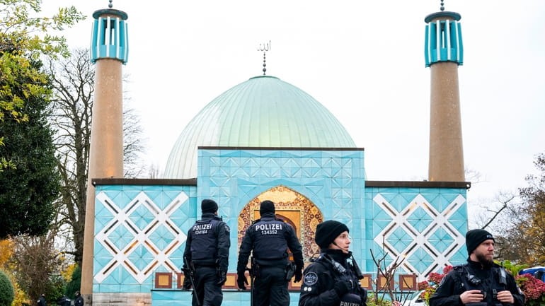 Police officers stand in front of the Imam Ali Mosque...