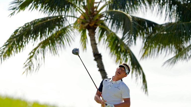 Carl Yuan watches his shot on the 14th tee during...