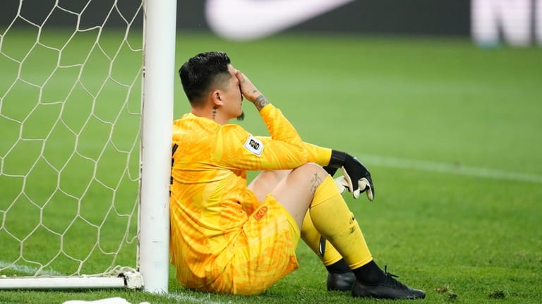 China's goalkeeper Wang Dalei reacts after the second round of...