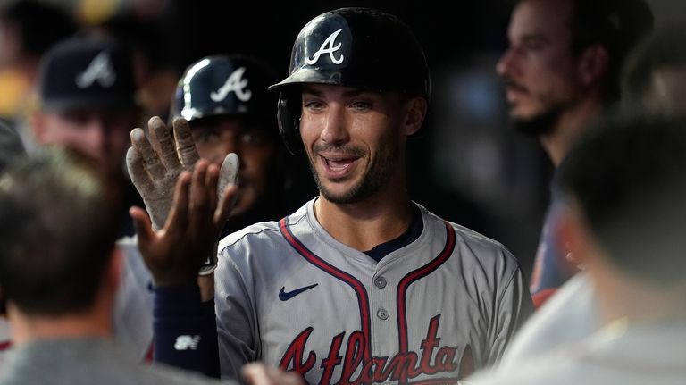 Atlanta Braves' Matt Olson, center, celebrates in the dugout after...