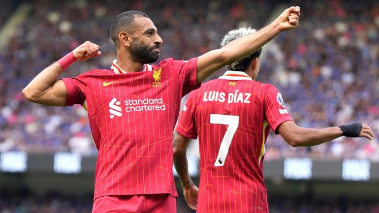 Liverpool's Mohamed Salah, left, celebrates after he scores his side's...