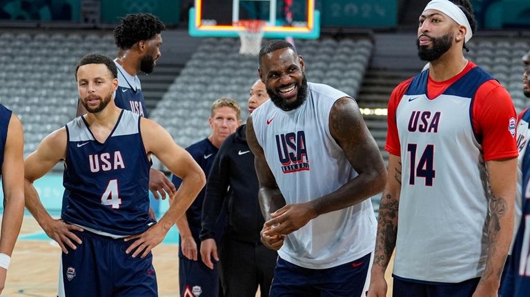 LeBron James, center, laughs between Stephen Curry, and Anthony Davis,...